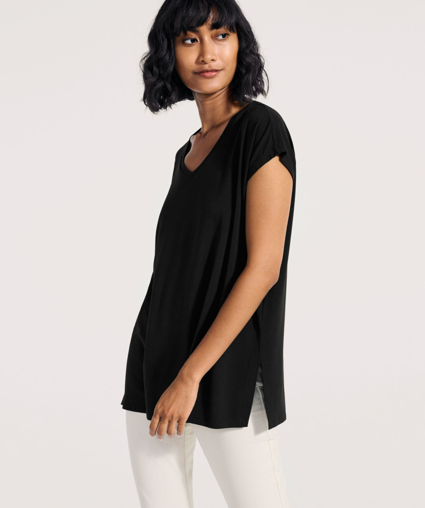Woman wearing black dress over pants. Woman wearing black dress over pants.