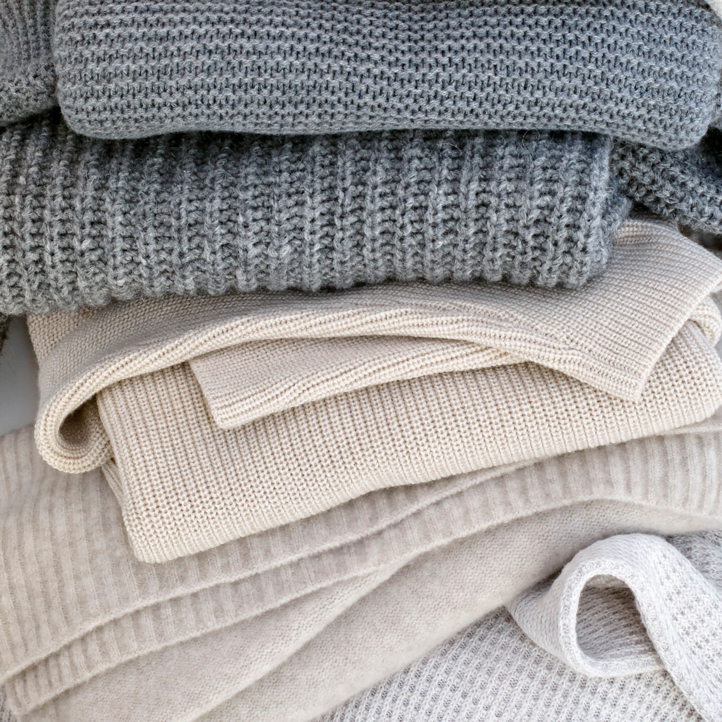 Stack of neutral sweaters and knits. Stack of neutral sweaters and knits.