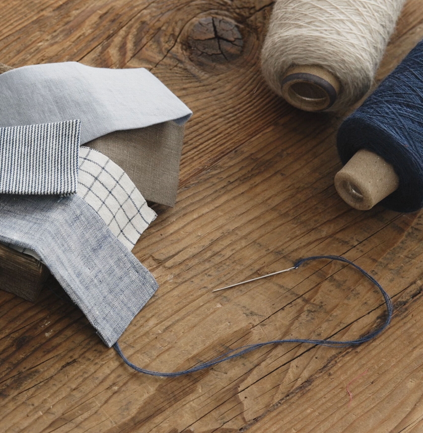 Thread, fabric patches, needle, and thread. Thread, fabric patches, needle, and thread.