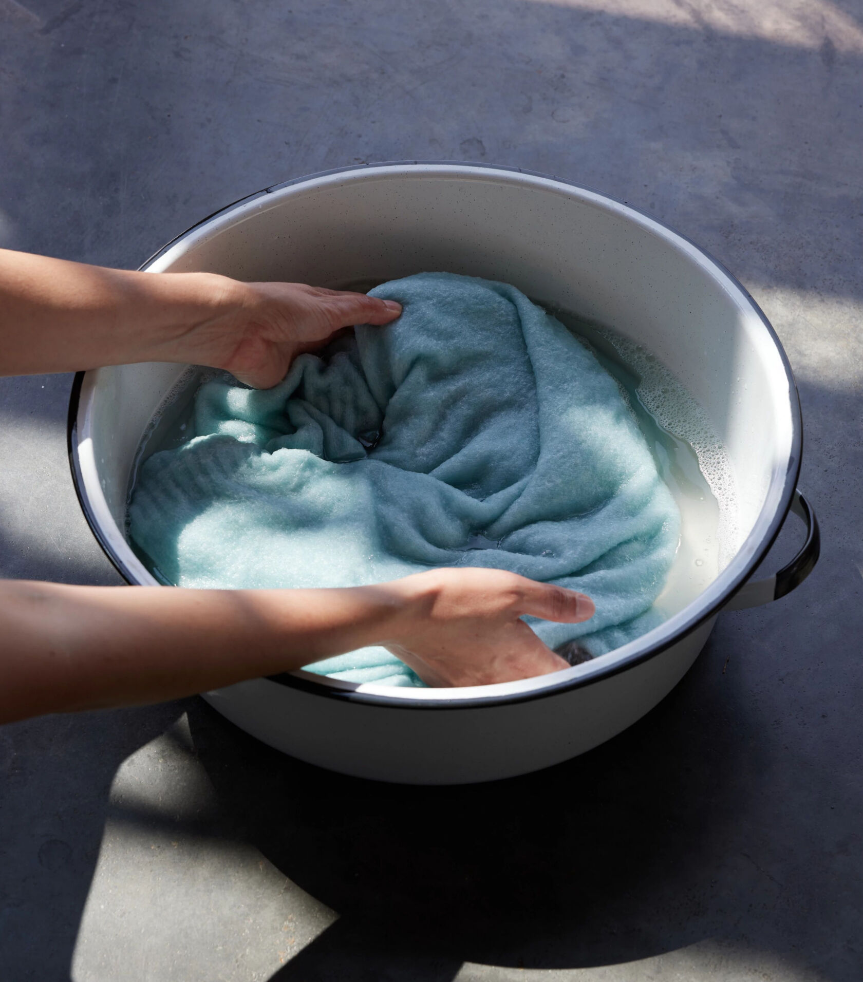 Woman hand washing a cashmere sweater. Woman hand washing a cashmere sweater.