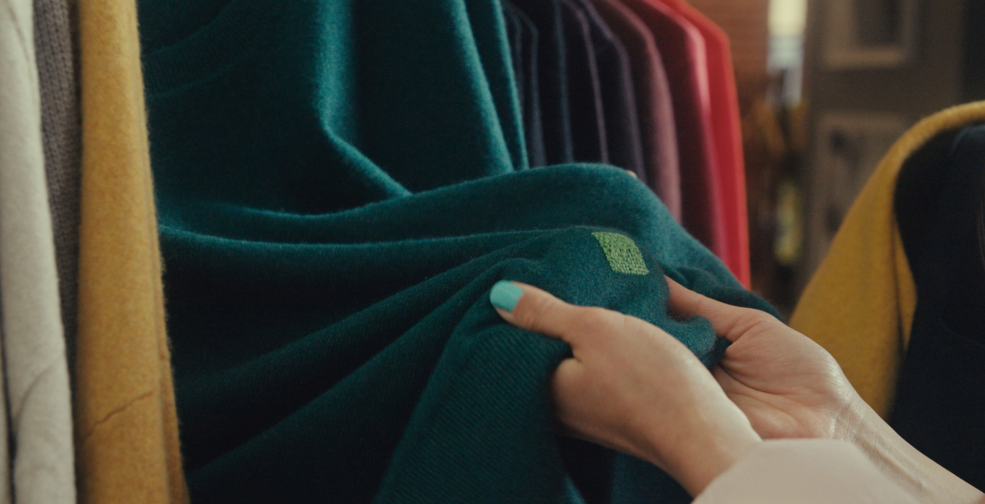 Close up of a colorful, visibly mended green sweater. Close up of a colorful, visibly mended green sweater.