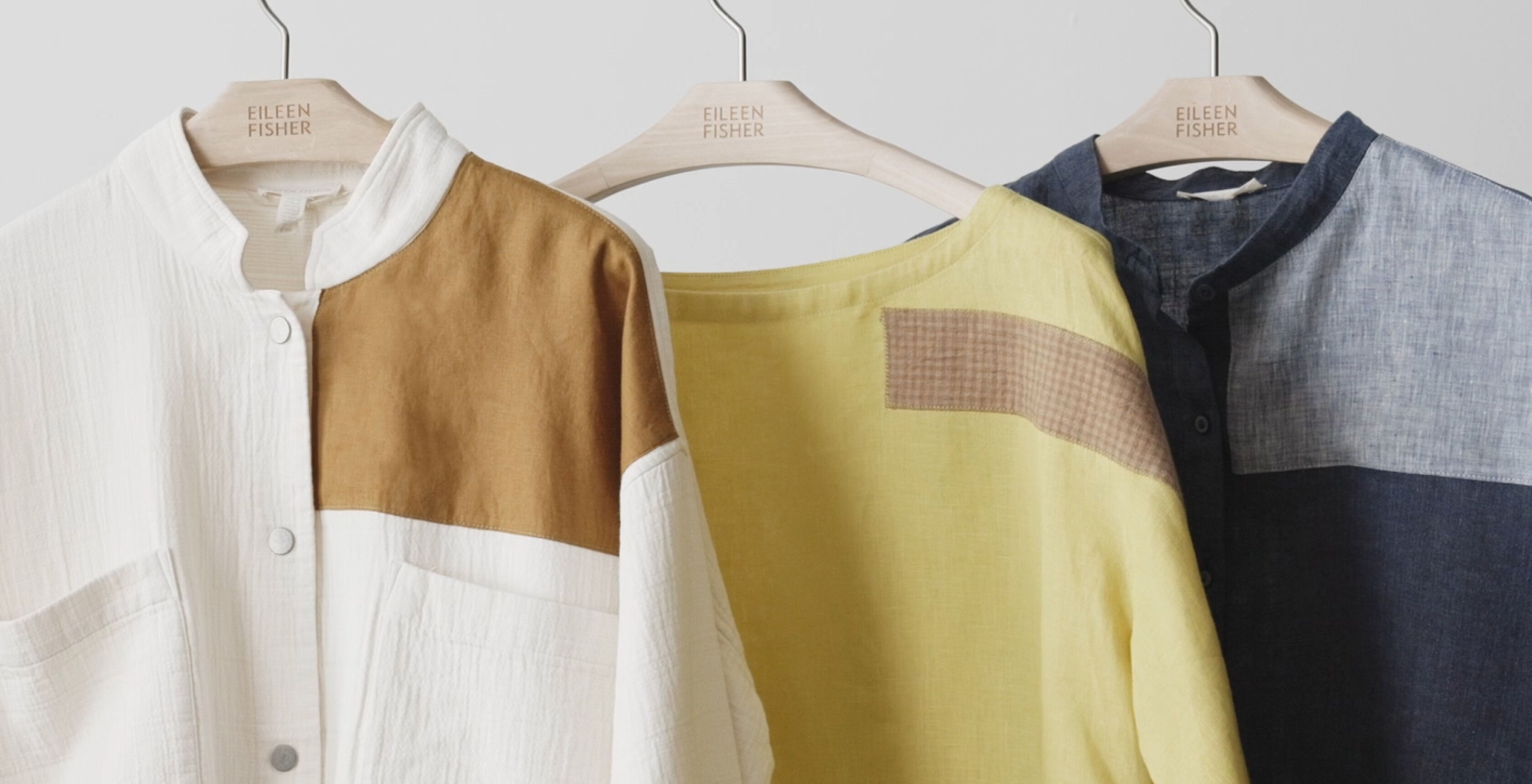 Colorful, visibly patched clothing on a rack Colorful, visibly patched clothing on a rack