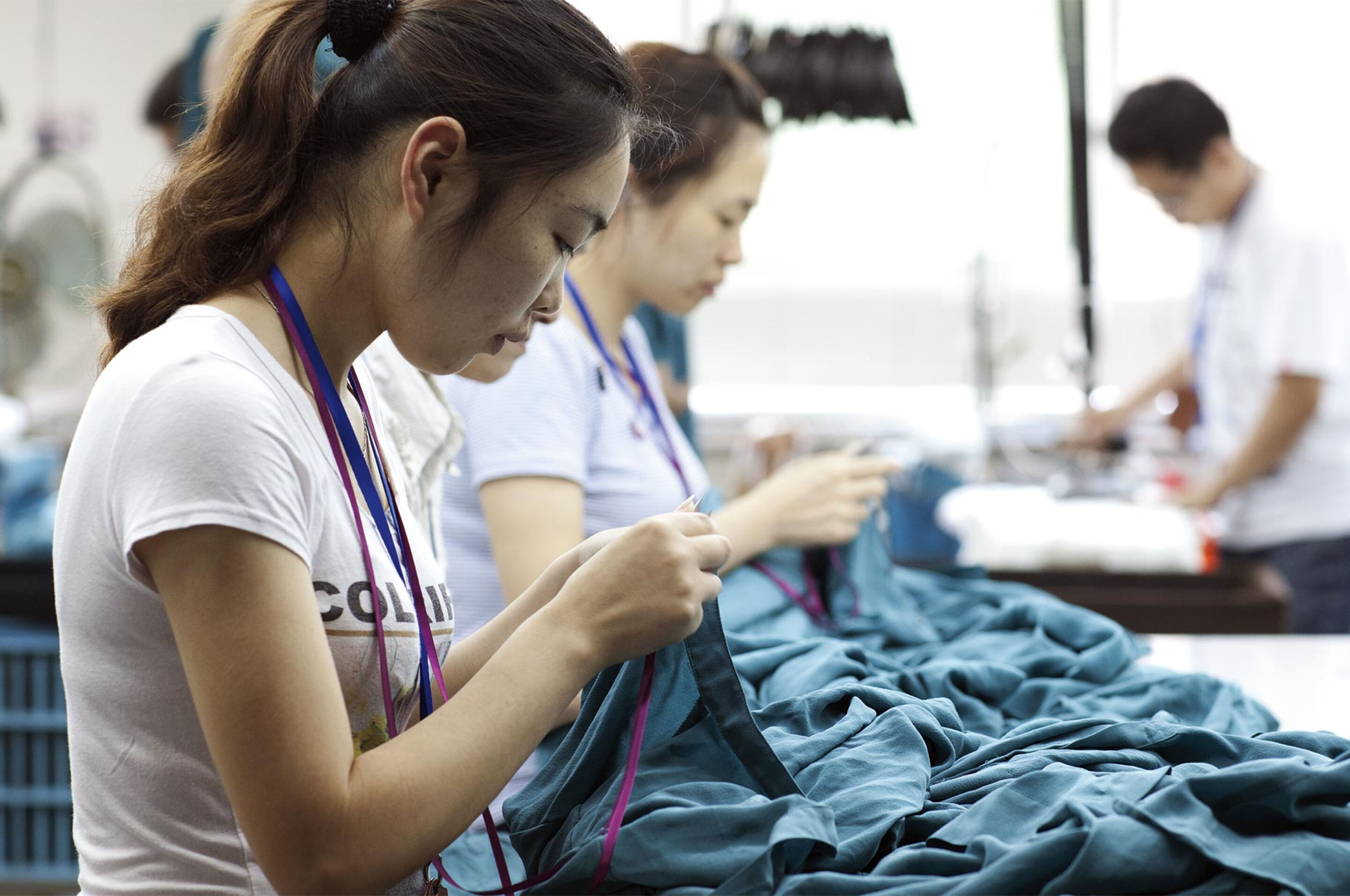 Women sewing at a clothing factory. Women sewing at a clothing factory.
