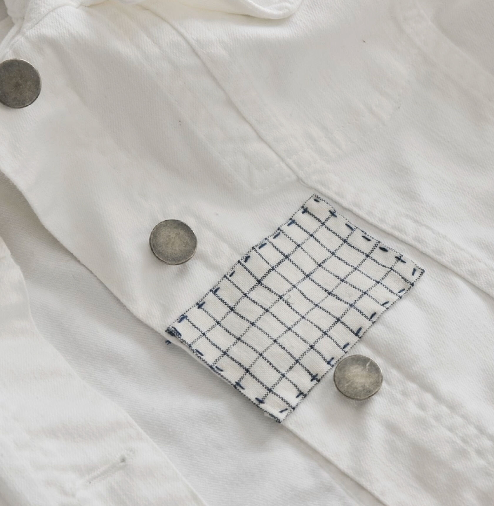 Finished blue and white rectangle patch on white denim jacket. Finished blue and white rectangle patch on white denim jacket.