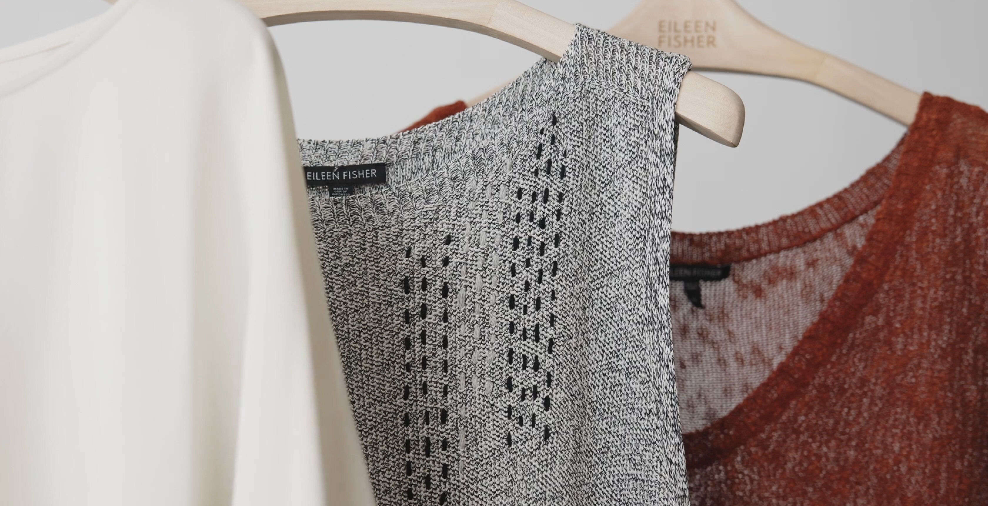 A damaged EILEEN FISHER garment that has been visibly mended with contrasting thread. A damaged EILEEN FISHER garment that has been visibly mended with contrasting thread.